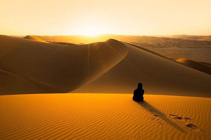 Experience the serene beauty of a desert sunrise with golden sands stretching endlessly. A perfect time for reflection and connection with nature alongside family and friends.